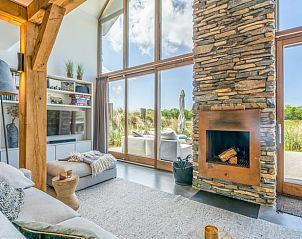 Houten open haard in Vakantiehuisje in De Koog met uitzicht op terras en natuur.