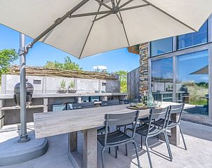 Buitenterras met eettafel in Vakantiehuisje in De Koog, Texel, omgeven door natuur.