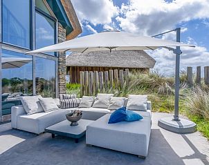 Loungehoek op terras van Vakantiehuisje in De Koog, Texel, met comfortabele zitplaatsen.