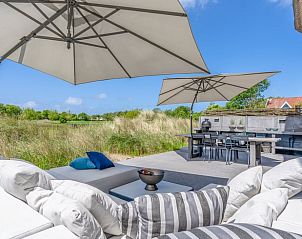Terras met parasols in Vakantiehuisje in De Koog, Texel, met uitzicht op de natuur.