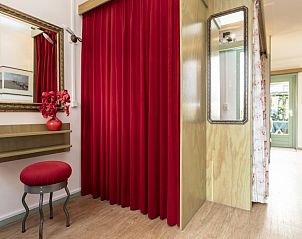 Stylish hall in vacation home Schanulleke, De Koog, Texel, with red curtains and mirror.