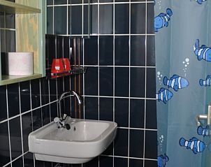 Modern bathroom in vacation home Schanulleke, De Koog, Texel, with sink and colorful shower curtain.