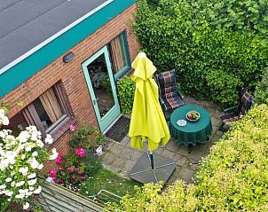 Sunny garden of Schanulleke, De Koog, Texel, vacation home with terrace furniture and green surroundings.