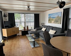 Cozy living room in Chalet Bregkoog 53, Texel, with modern decor and lots of natural light at Chaletpark Bregkoog.