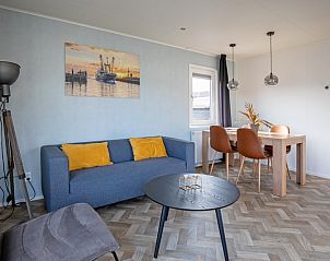 Dining area in Chalet Park Bregkoog - Chalet Bregkoog 162, Texel with wooden table and comfortable chairs for cozy meals.