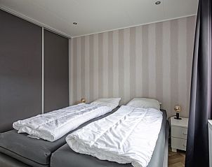 Second bedroom in Chalet Bregkoog 162, De Koog, Texel with two single beds and practical storage space.