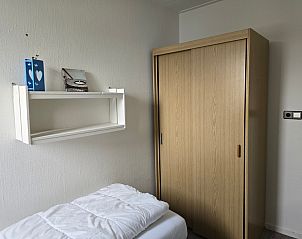 Stauraum im Schlafzimmer von Apartments Anna - Apartment 15 in De Koog, Texel, mit Holzschrank und Wandregal.