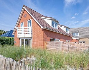 Vogelweelde vacation accommodation in De Koog, Texel with sunny garden and wooden fence.