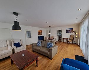 Open leefruimte in Bungalow Epelaan 13, De Koog, Texel, met moderne meubels en houten vloer.