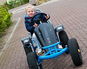 Child plays on go-kart at Villa 6, De Koog Texel, child-friendly vacation home on the Wadden Islands.