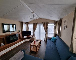Cozy living room in Chalet Bregkoog 16 Zanderij, De Koog Texel, with comfortable seating area and large windows.