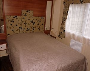 Bedroom in Chalet Bregkoog 16 Zanderij, De Koog Texel, with double bed and warm decoration.