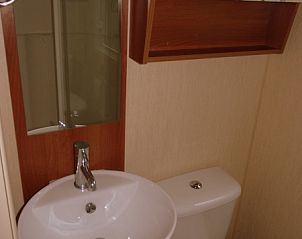 Compact bathroom in Chalet Bregkoog 16 Zanderij, De Koog Texel, with stylish sink and toilet.