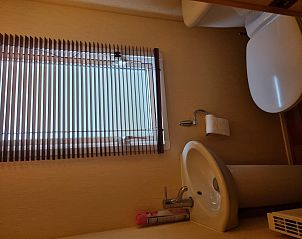 Bathroom in Chalet Bregkoog 16 Zanderij, De Koog Texel, with toilet and sink, provided with natural light.