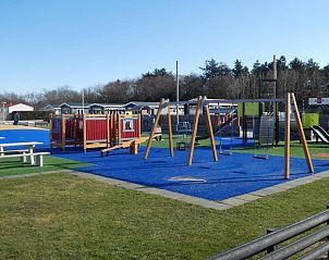 Gerumiger Spielplatz mit Schaukeln und Rutschen im Chalet Bregkoog 27, ideal fr Familien in De Koog, Texel.