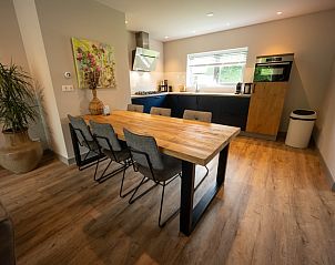 Dining area in Landgoed Springtij - Stulpje in De Koog Texel with wooden table and comfortable chairs.