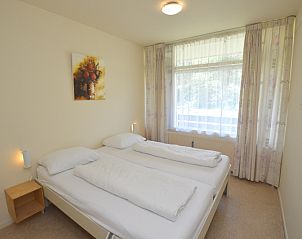 Schlafzimmer im Appartement Kerckeland 64, De Koog, Texel, mit bequemen Betten und viel Tageslicht.