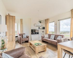 Modernes Wohnzimmer im Apartment Juliana 170 Eilandzicht, De Koog, Texel mit Flachbildfernseher und Blick auf die Natur.