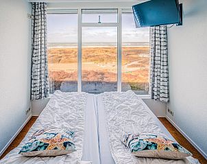 Slaapkamer met panoramisch uitzicht op de duinen in Appartement Juliana 164 Zeezicht, Texel.
