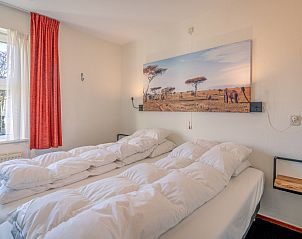 Comfortable bedroom with double bed in Apartment Zeedistel 20, De Koog, Texel with views of the surroundings.