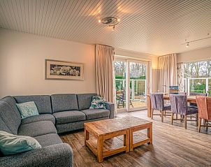 Spacious living room of Orchismient 2, vacation home in De Koog, Texel with comfortable sofa and dining area.