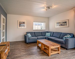 Cozy sitting area in Orchismient 2, vacation home Texel, with large sofa and wooden coffee table.