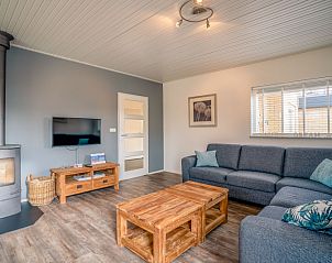 Modern living room with wood stove in Orchismient 2, vacation home De Koog, Texel.