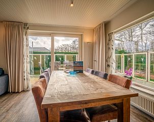 Dining area overlooking garden in Orchismient 2, vacation home De Koog, Texel for cozy meals.