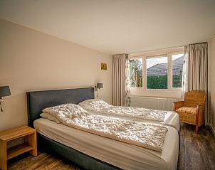Spacious bedroom with large window in Orchismient 2, vacation home De Koog, Texel for natural light.