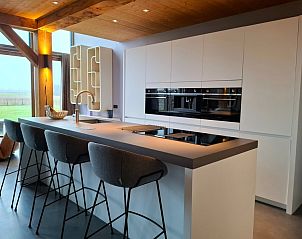 Dining area in Villa 189 with Hot tub on Texel with wooden ceiling and spacious dining table.