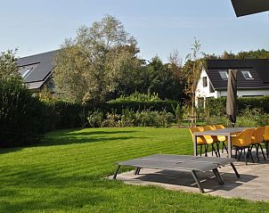 Kingfisher 10 in De Koog Texel with spacious garden and comfortable deck chairs for relaxation.