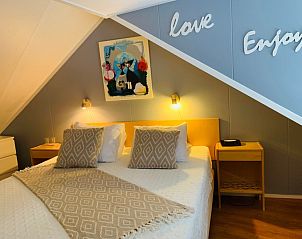 Knusse slaapkamer in Texel A, De Koog, met tweepersoonsbed en sfeervolle decoratie.