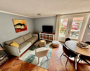 Ruime woonkamer in Texel A, De Koog, met toegang tot de tuin en veel natuurlijk licht.