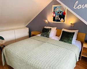 Slaapkamer met tweepersoonsbed in Texel A, De Koog, met moderne inrichting en comfortabele bedden.
