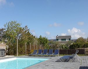 Zwembad en ligstoelen bij Huize 100-1, vakantiehuis in De Koog, Texel, perfect voor ontspanning.