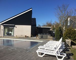 Zonovergoten zwembad bij Huize 100-1, een vakantiehuis in De Koog, Texel, met comfortabele ligstoelen.