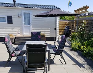 Cozy outdoor terrace with parasol at Chaletpark Bregkoog - Chalet Bregkoog 138 'Sinne' in De Koog, Texel, suitable for sunny days.