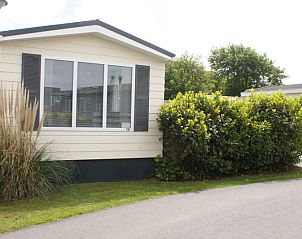 Exterior of Chalet Bregkoog 138 'Sinne' in Chaletpark Bregkoog, De Koog, Texel, surrounded by lush nature.