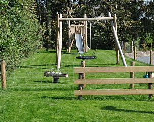 Spielplatz in Tapuit 10a, Ferienhaus in De Koog, Texel mit Schaukel und Rutsche.