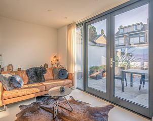 Cozy living room in vacation home Het Bospad - Brink 15, De Koog, Texel. Comfortable sofa and lots of natural light.