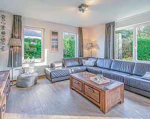 Bright living room of Holiday Home Honeysuckle 31, De Koog, Texel, overlooking the green garden.