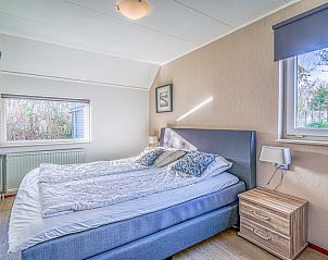 Bedroom with comfortable double bed in Holiday home Kamperfoelie 31, De Koog, Texel, overlooking the garden.