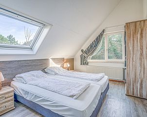 Bright bedroom under sloping roof in Holiday home Kamperfoelie 31, De Koog, Texel, with two single beds.
