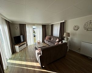 Helles Wohnzimmer im Chalet Bregkoog 213, Chaletpark Bregkoog, De Koog Texel, mit Blick auf den Garten.