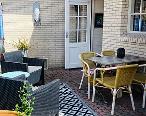 Sunny terrace of Texel C vacation home in De Koog, Texel, with dining area and cozy sitting area.