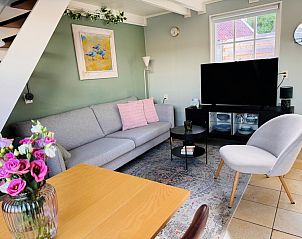 Cozy sitting area in Texel C vacation home, De Koog, Texel, with modern furniture and colorful flowers.