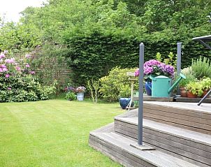 Flowering garden at Holiday home in De Koog with wooden terrace, Texel, Wadden Islands.