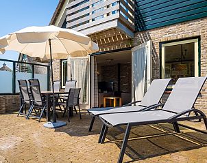Sunny terrace of Villa pet-free in De Koog, Texel with parasol and deck chairs on the Wadden Islands.