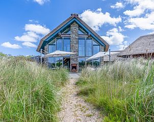 Villa 193 in De Koog, Texel, vacation home with modern architecture and thatched roof, surrounded by dunes and nature.