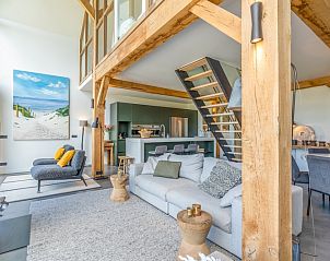 Open kitchen and sitting area in Villa 193, vacation home in De Koog, Texel, with wooden beams and modern furnishings.